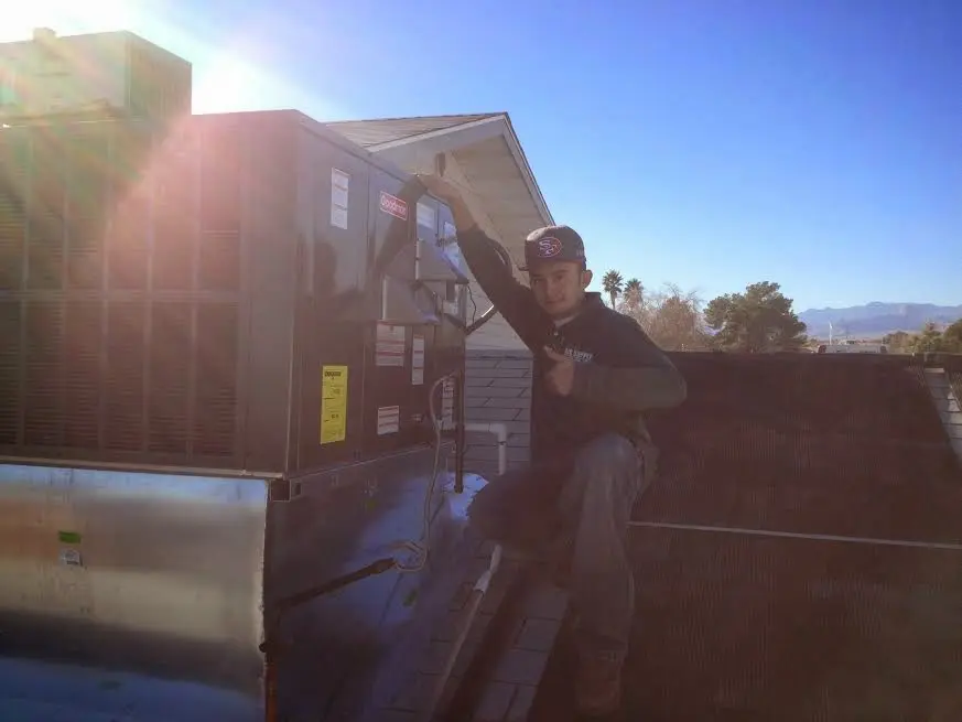 HVAC technician performing AC Tune-Up on a rooftop unit in Viera East